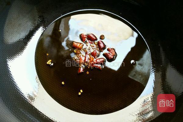  热锅下菜籽油烧至微帽青烟，下花椒和红干椒炒香，关火捡去花椒、红干椒不用。 