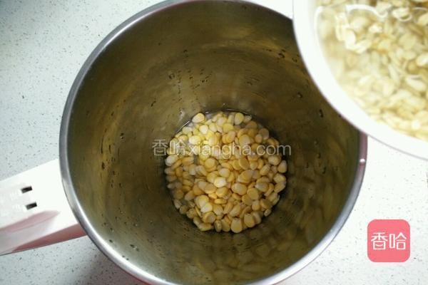  豆浆机里倒入玉米粒、燕麦片(连泡的水一起倒入)。 