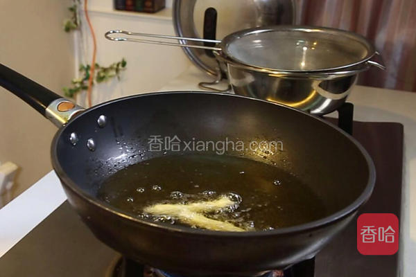  锅中烧热放油300克左右，大火烧至六七成热，把茄子条包上和好的糊放入锅中炸，金黄色捞出放入漏勺控油备用。 